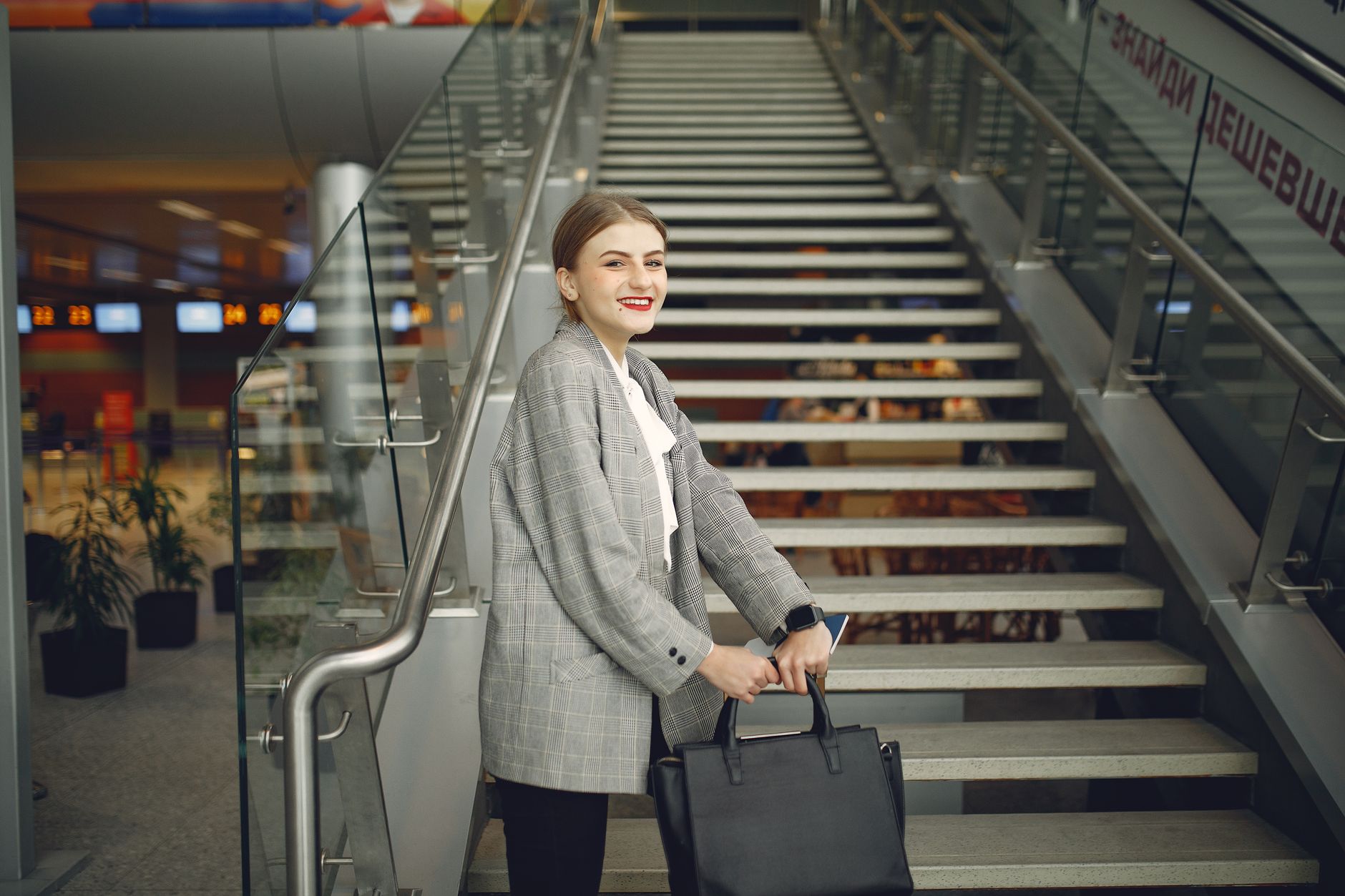 woman holding cat carrier at airport terminal