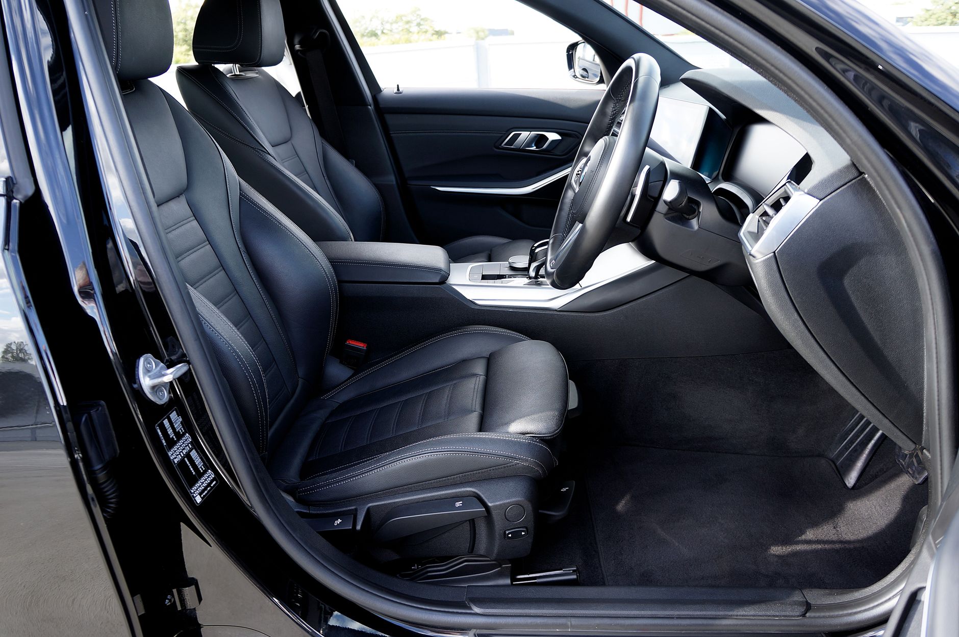hard-sided cat carrier secured on car floor behind front passenger seat