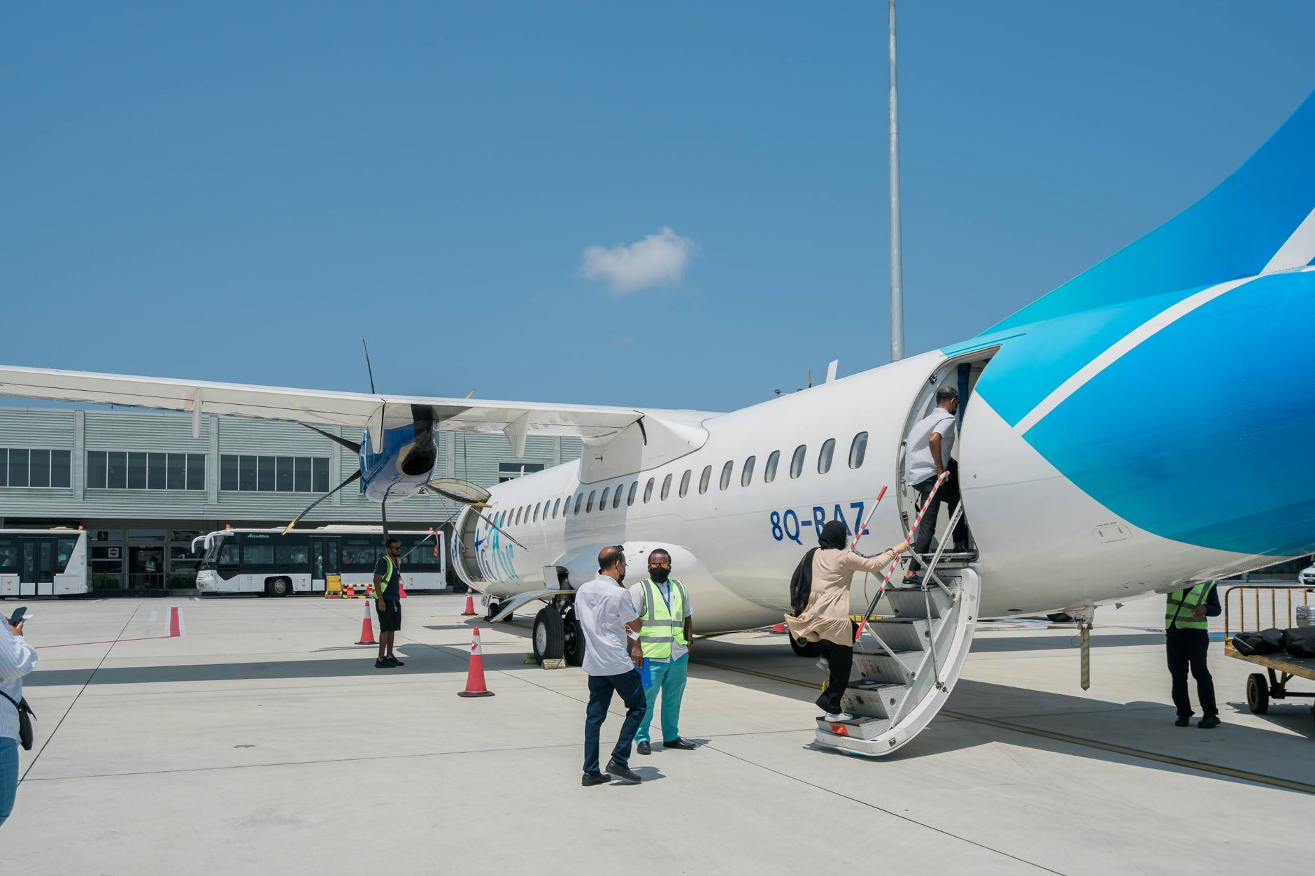 passenger holding pet kennel beside aircraft boarding gate
