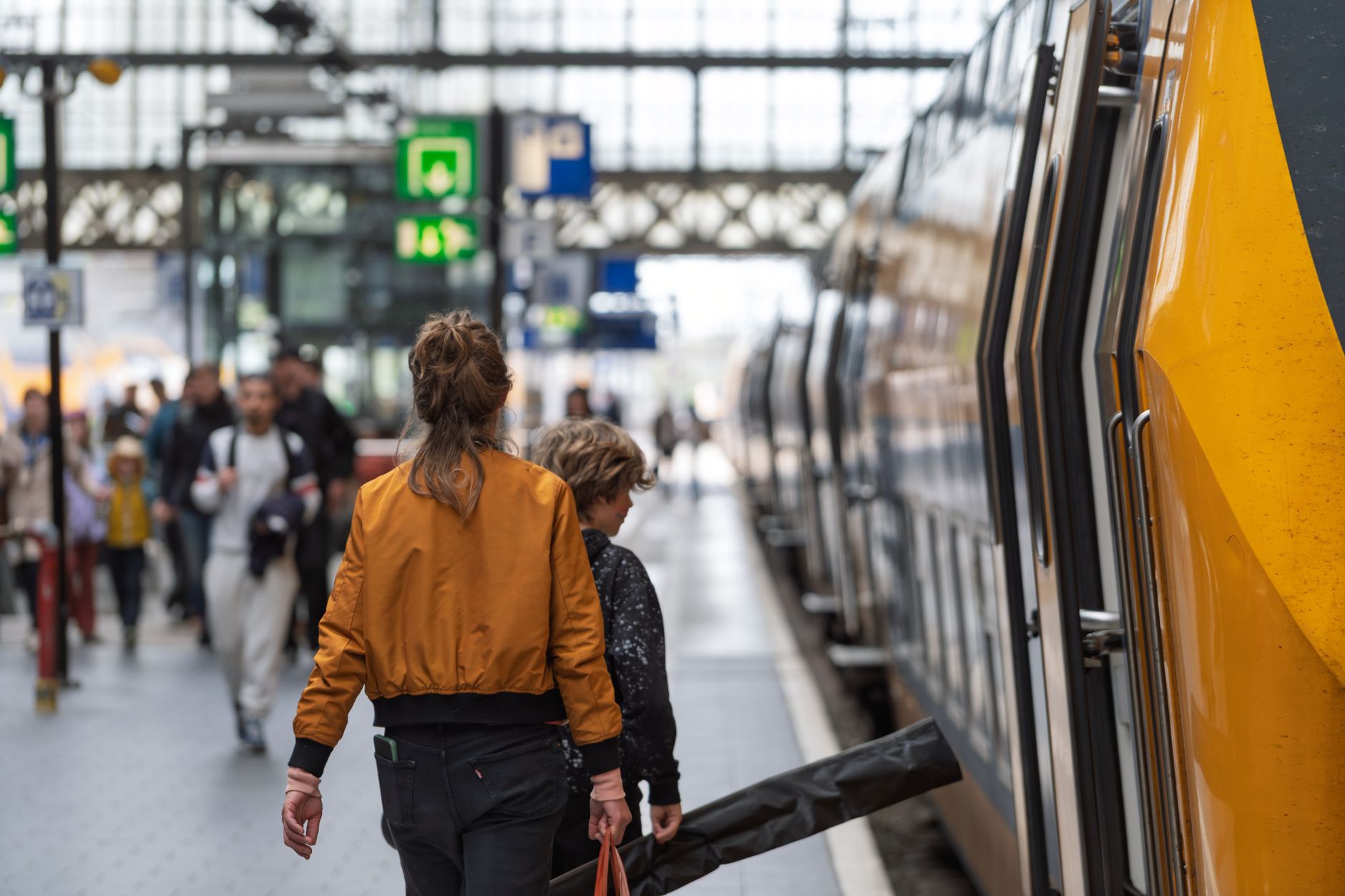woman with cat carrier waiting at European train station platform