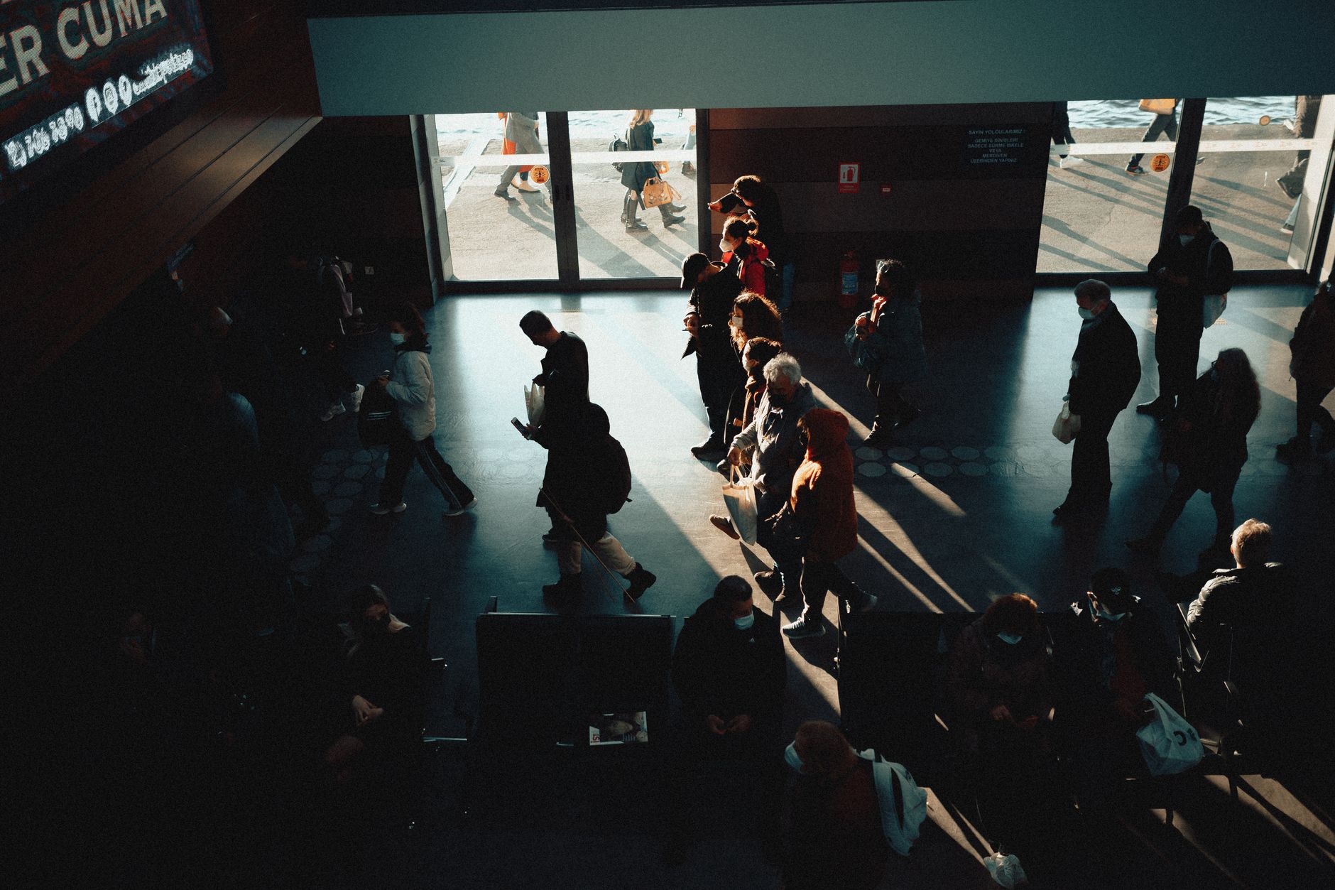 family walking leashed dog through ferry terminal boarding queue