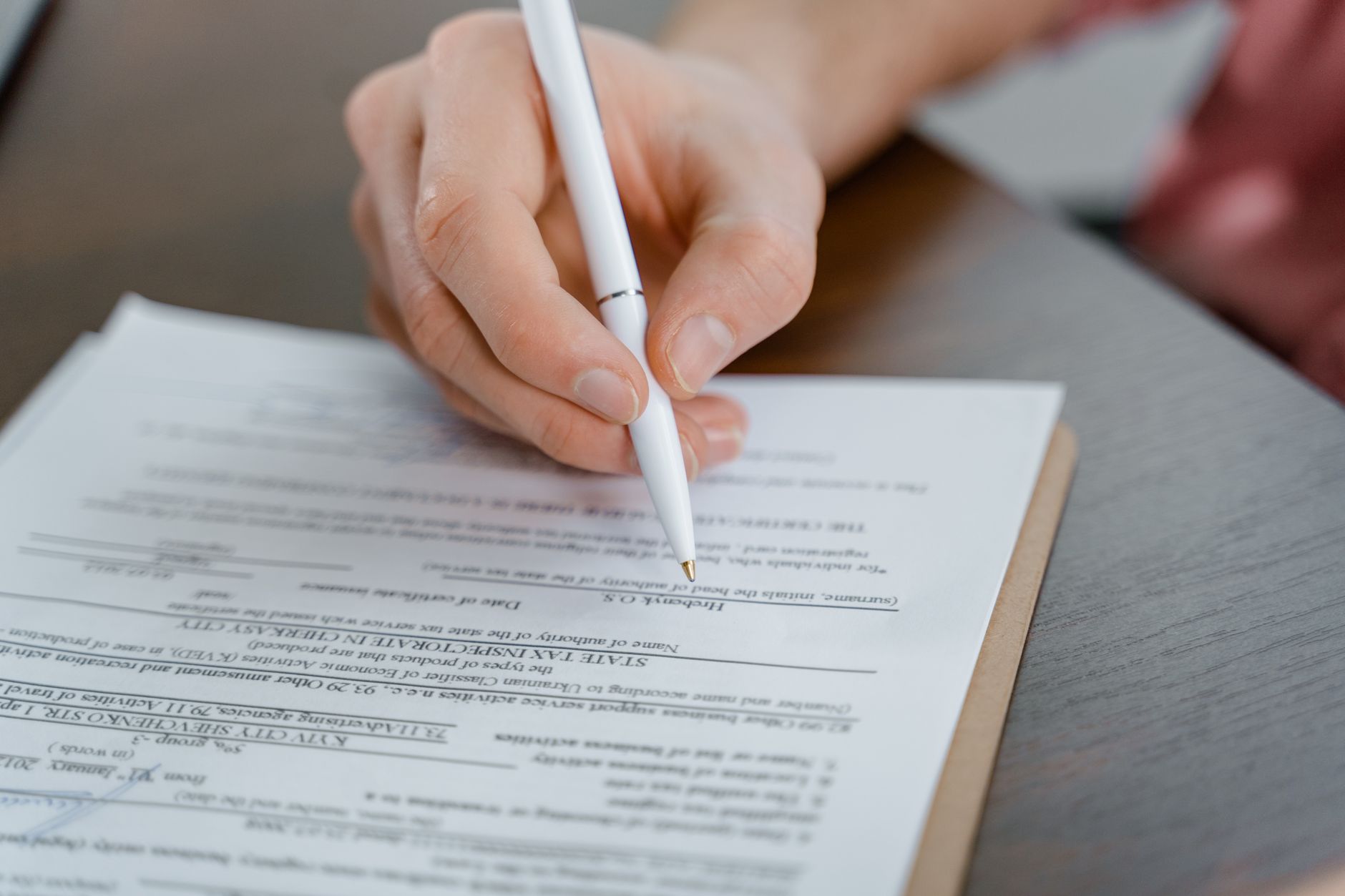 farmer filling out paperwork at wooden desk with cattle in barn