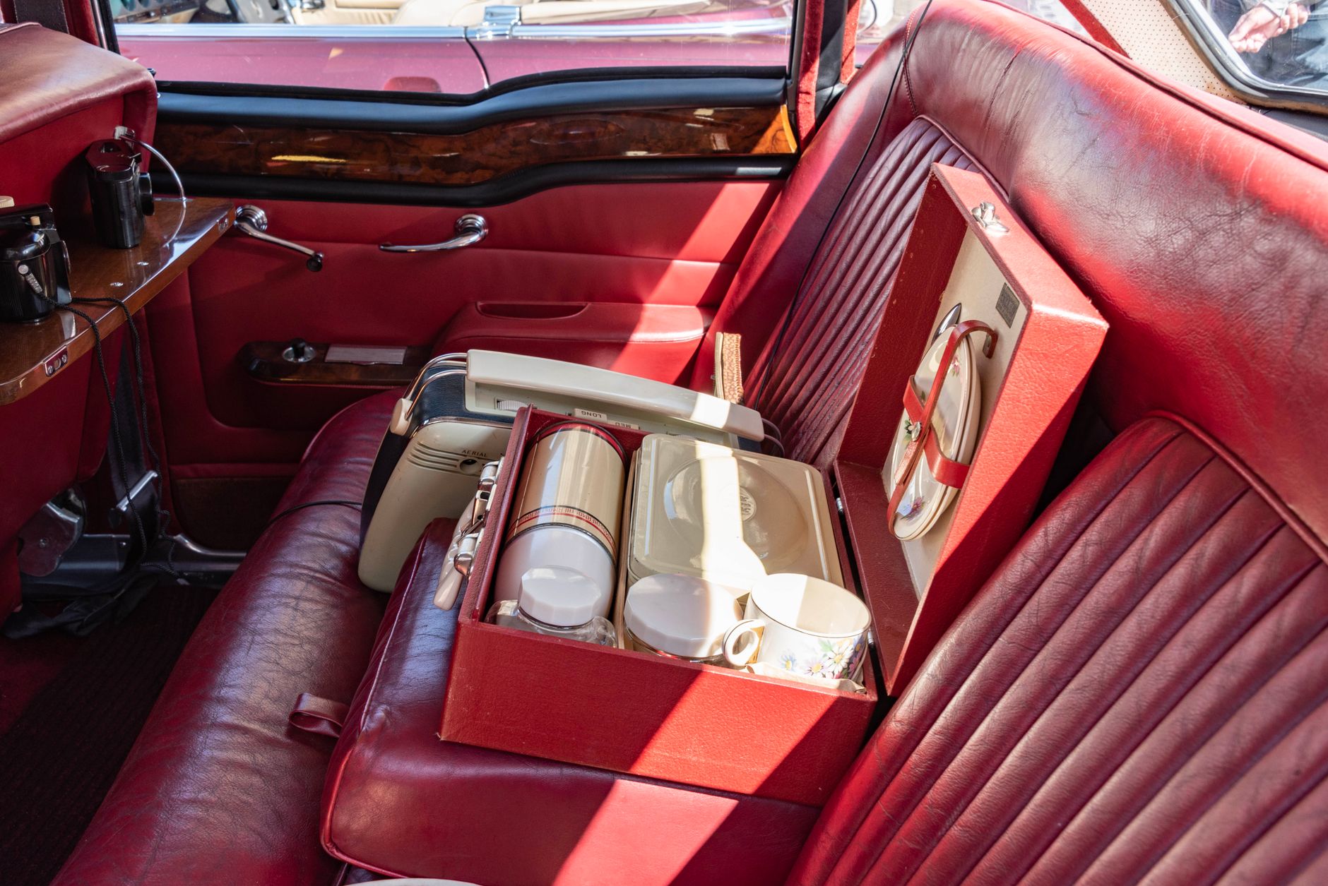 cat carrier secured on back seat floor of car during road trip
