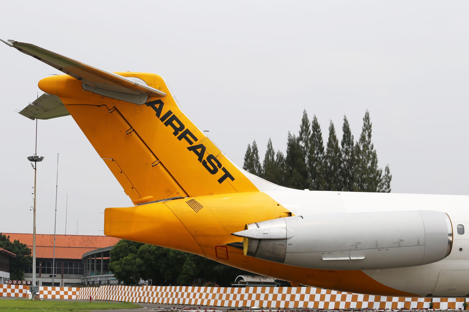 empty airport check-in counter with grounded yellow airplane outside window