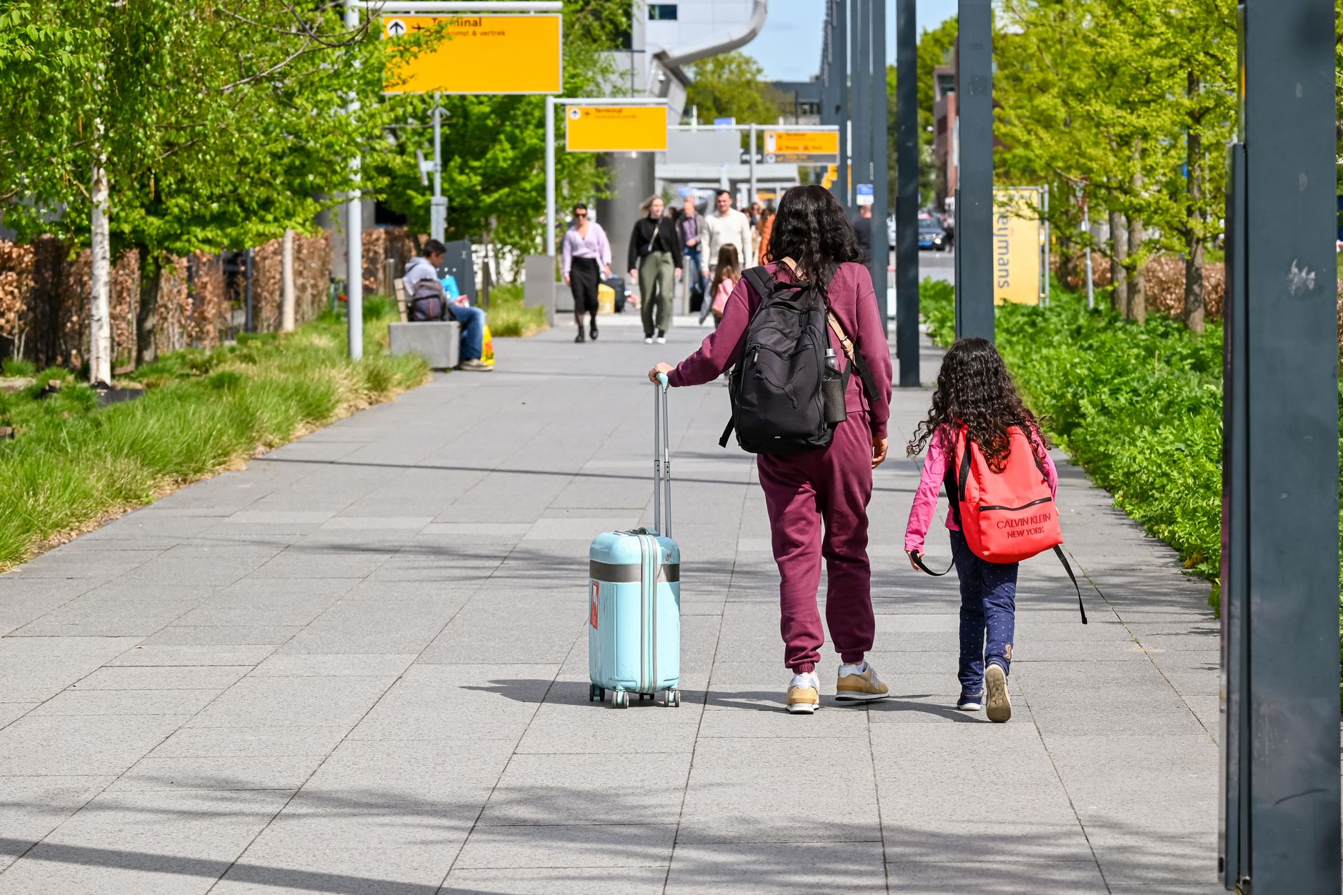 family walking dog past US customs and border protection sign airport