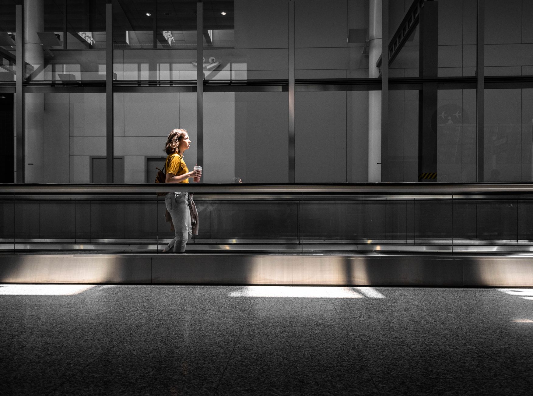 woman holding small dog carrier at airport terminal