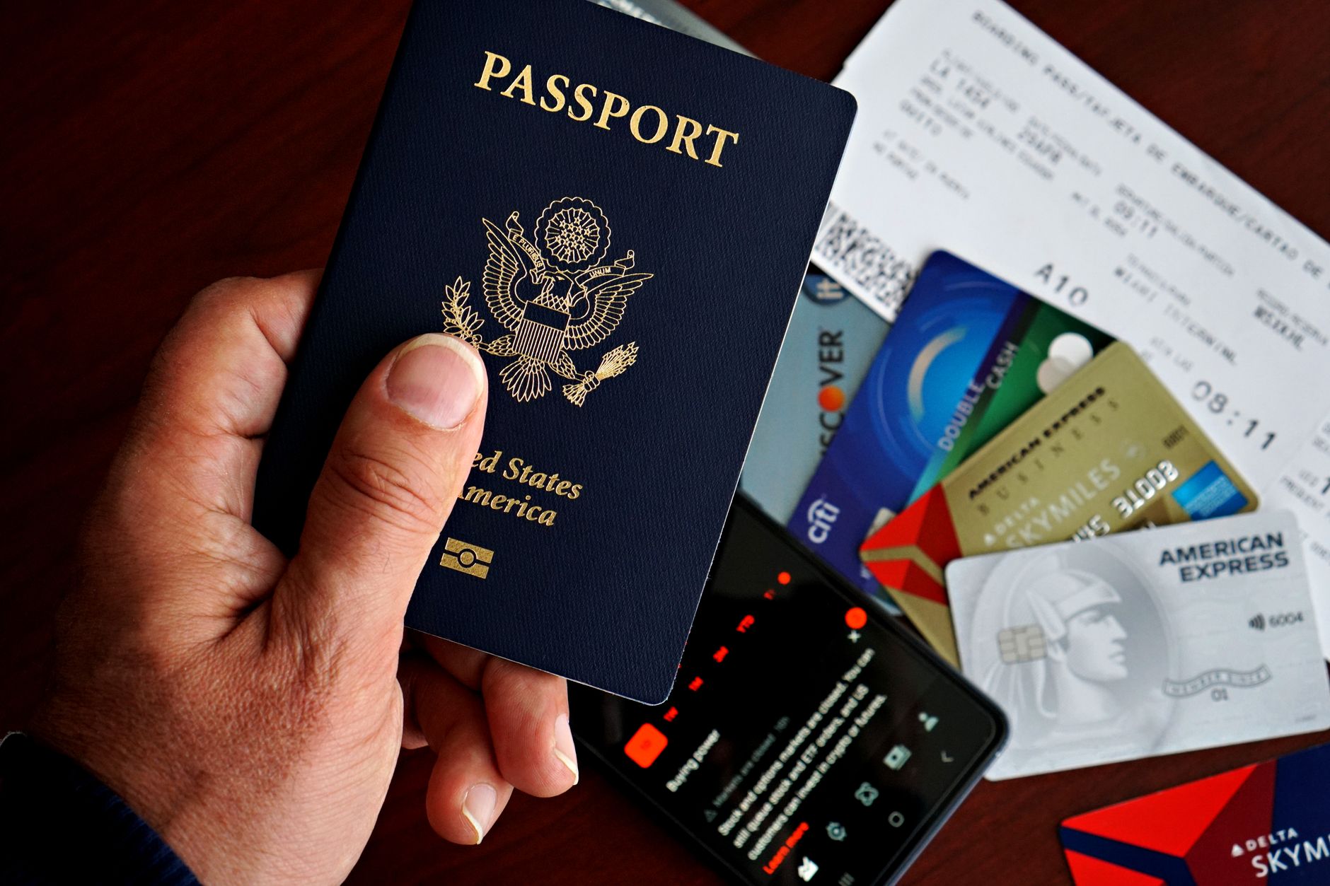traveler holding passport and boarding pass beside labrador assistance dog at check-in counter