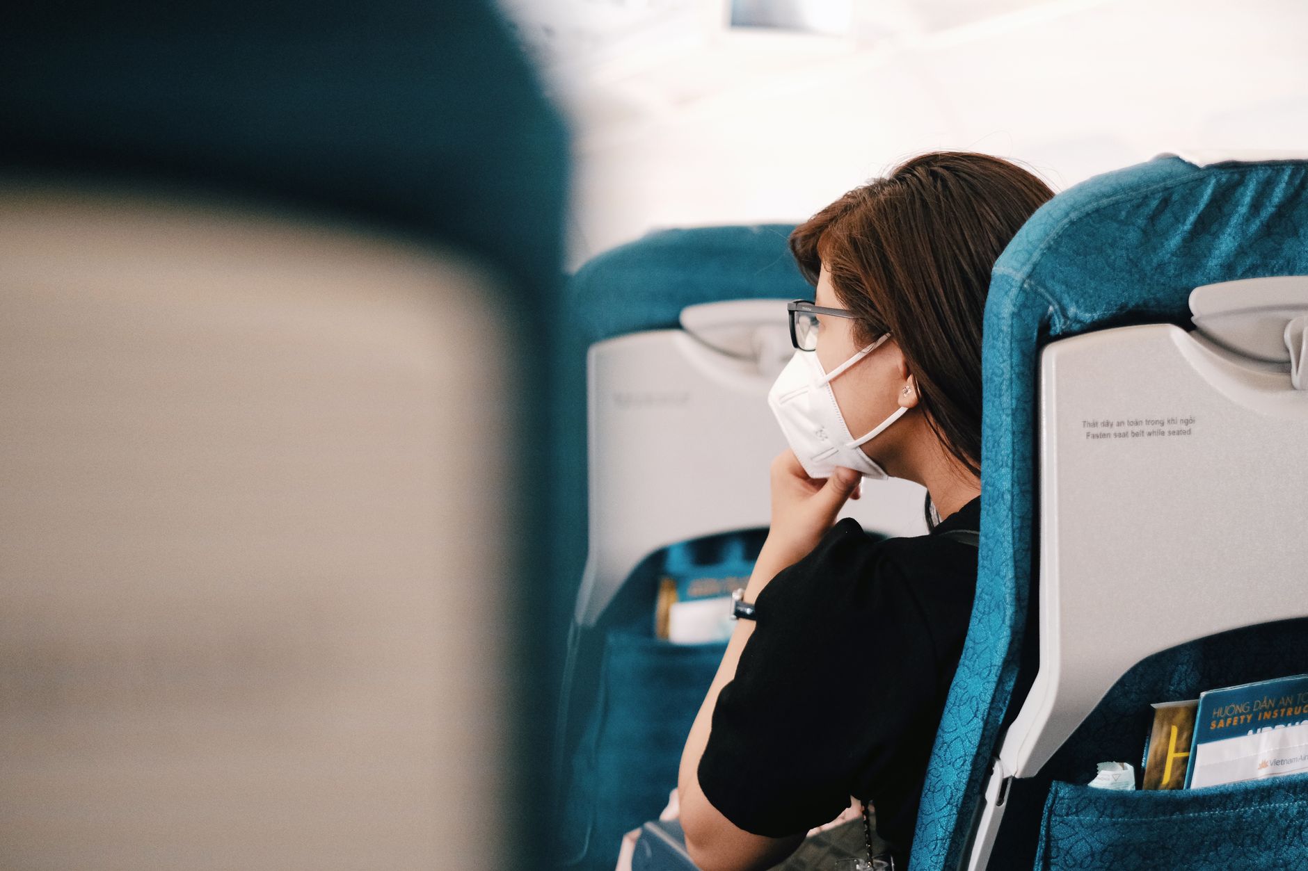 passenger measuring pet carrier with tape beside airline seat