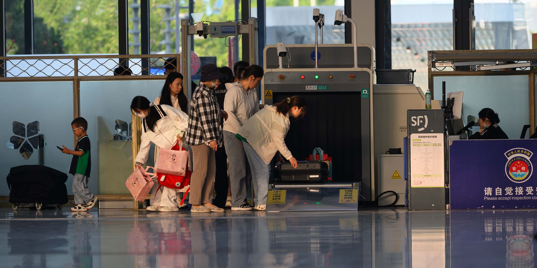 traveler holding cat through TSA security checkpoint screening lane