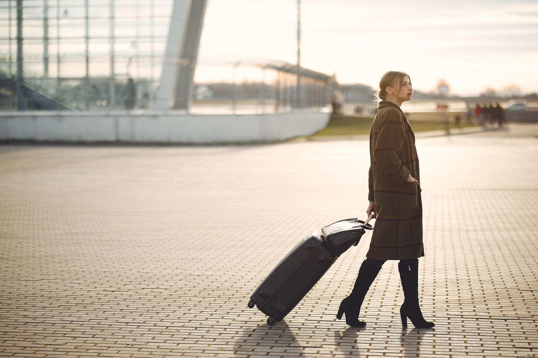 woman walking through airport terminal with cat carrier
