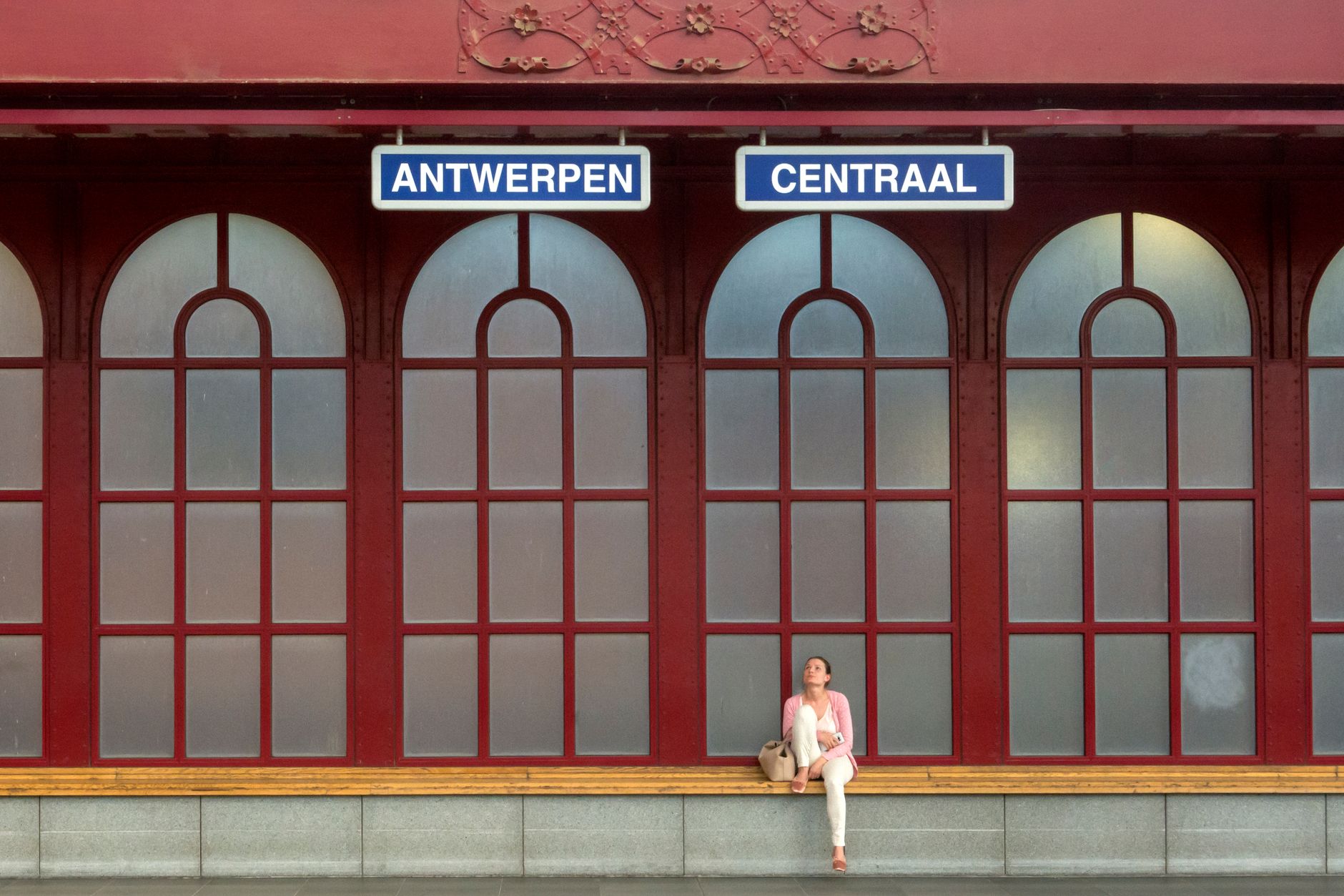 woman with cat carrier waiting at European train station platform