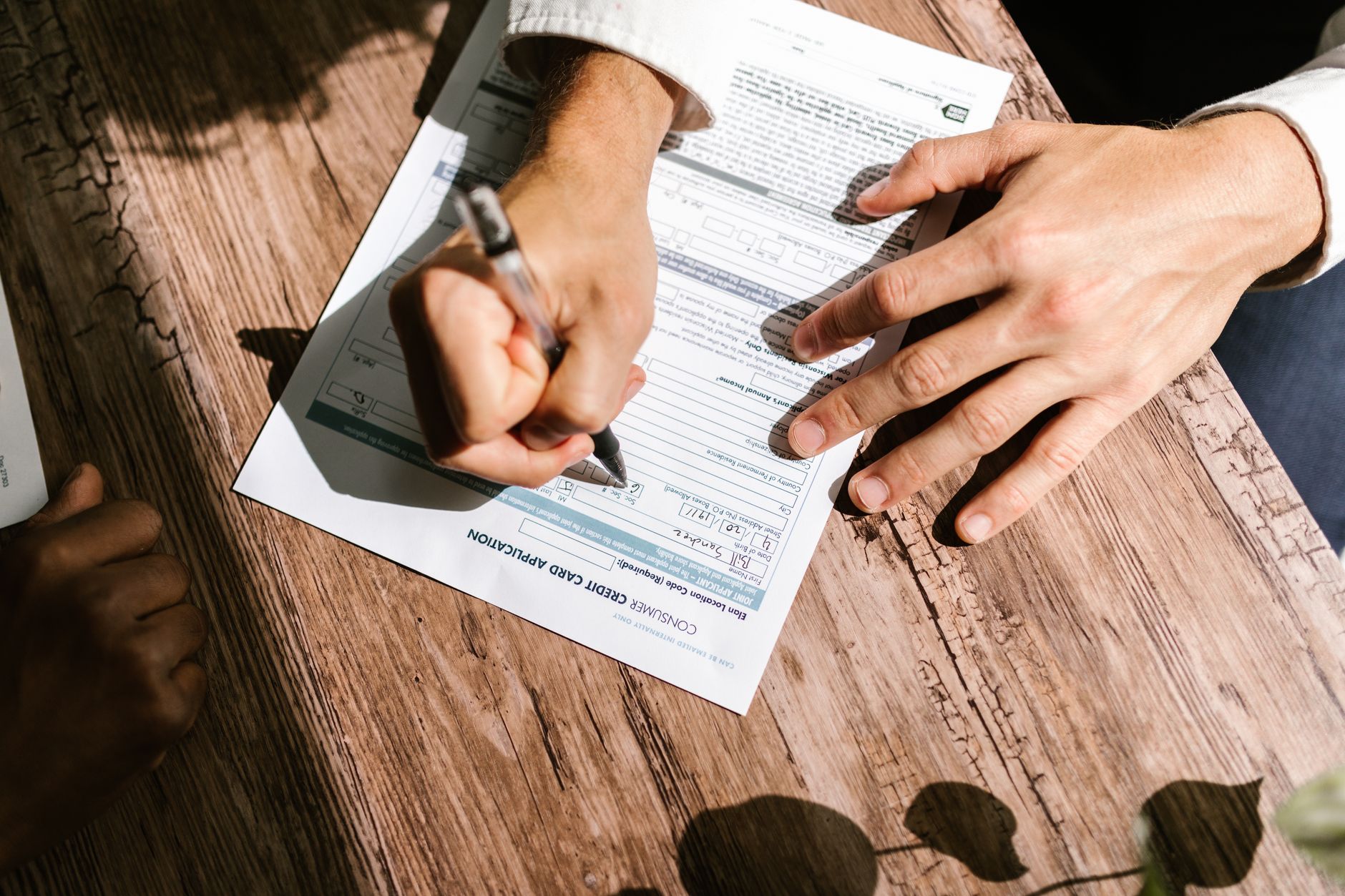 traveler filling out import paperwork airport check-in desk with dog carrier