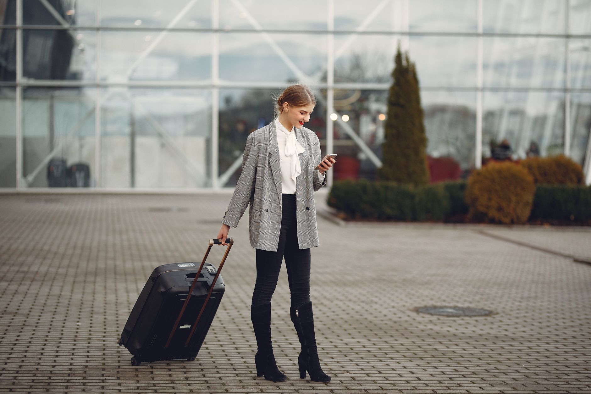 woman carrying dog travel bag through airport terminal