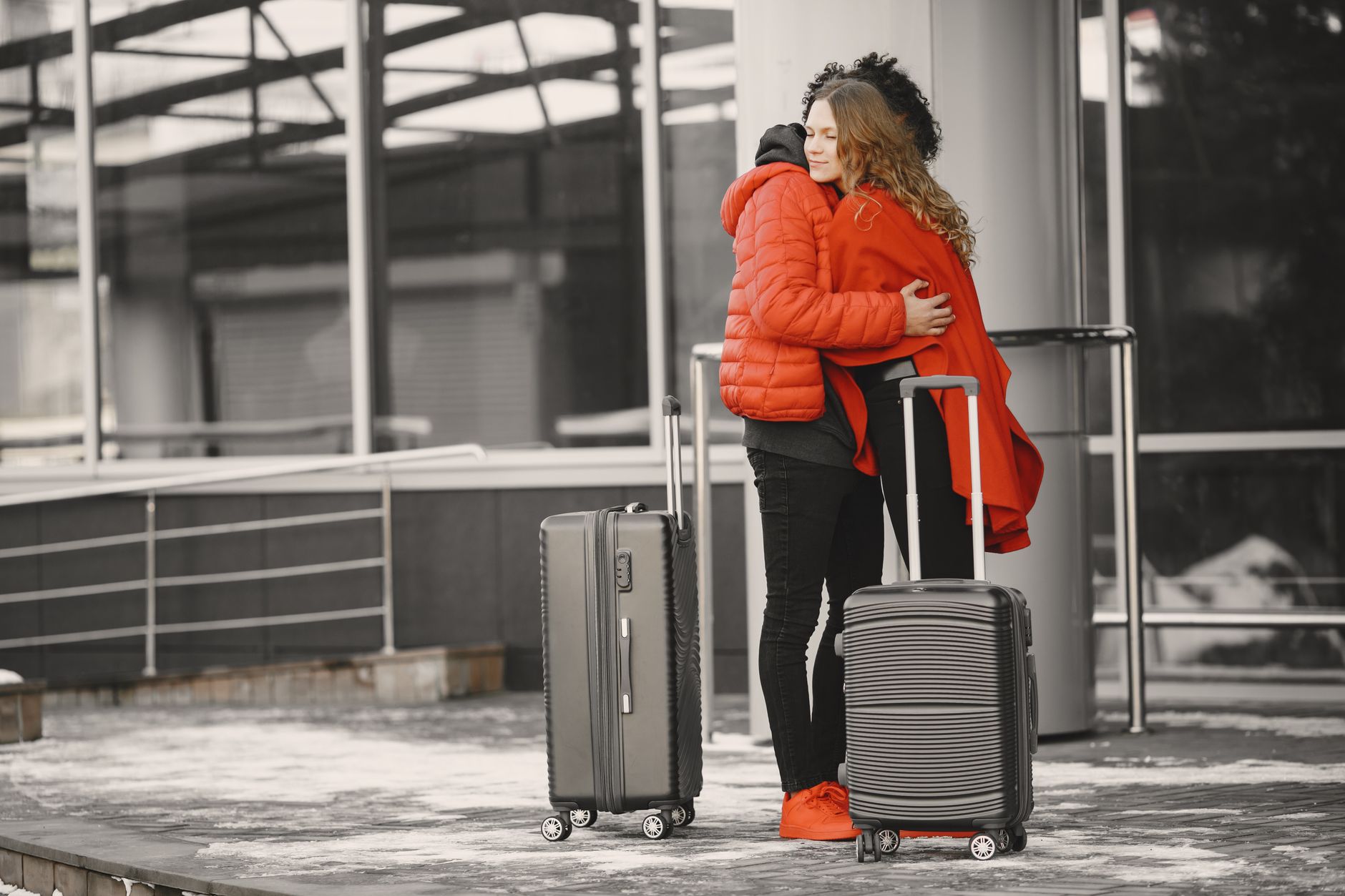 woman waving goodbye to cat in pet crate at airport check-in
