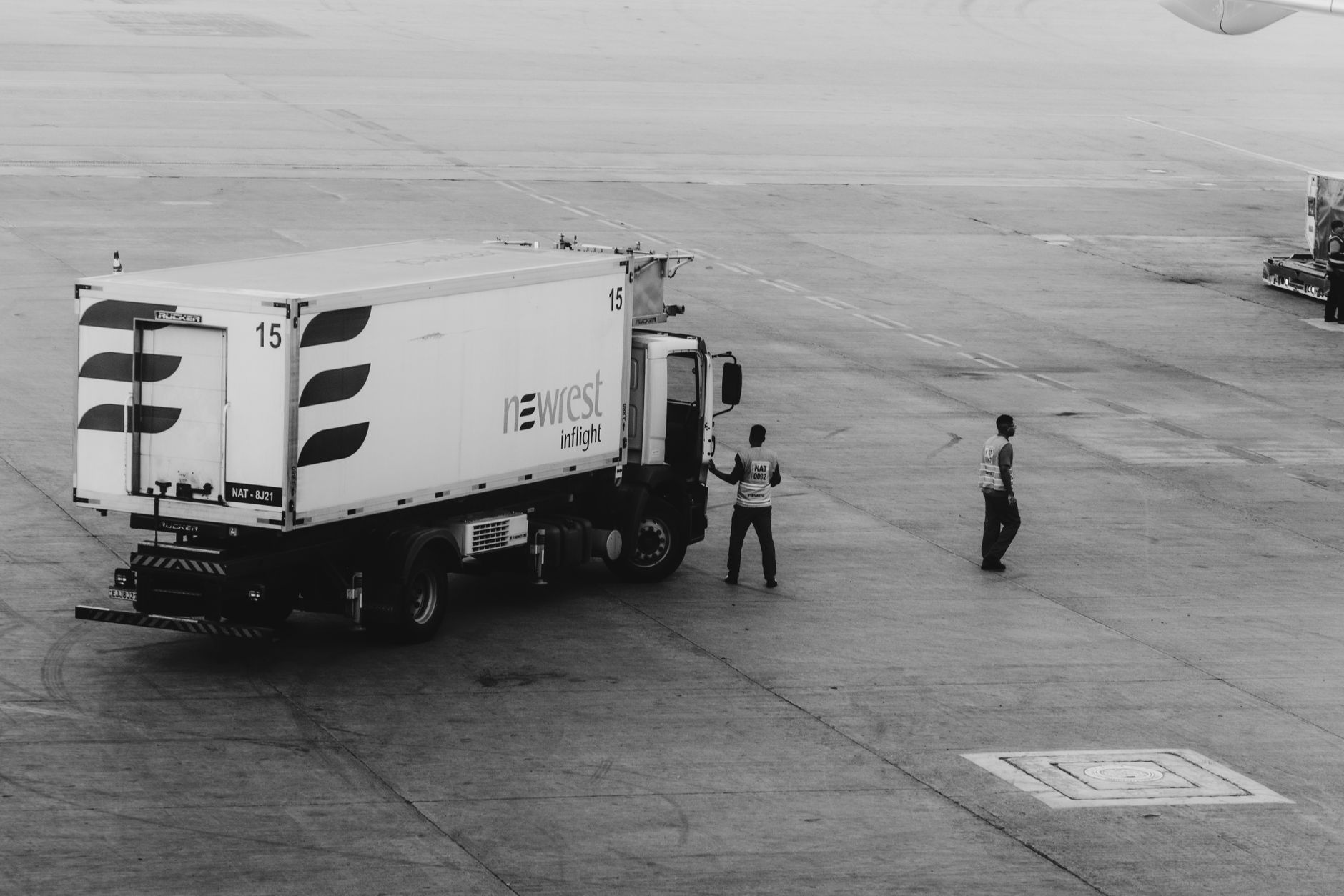 airline cargo worker loading pet crate on tarmac