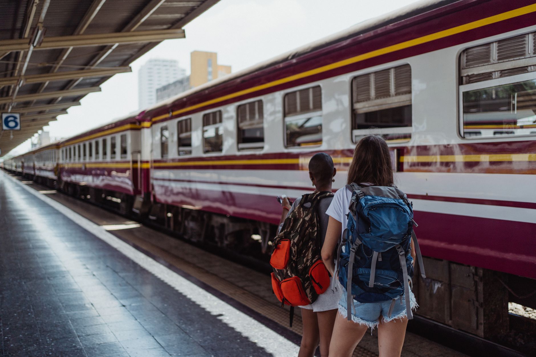 dog peeking out of backpack carrier on train platform
