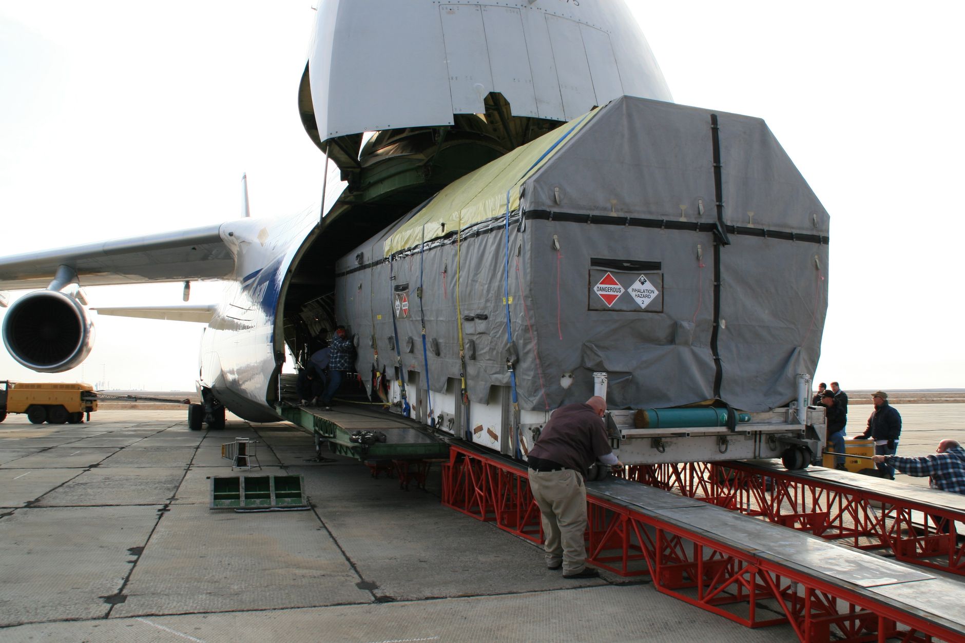 large dog crate being loaded into cargo hold at airport