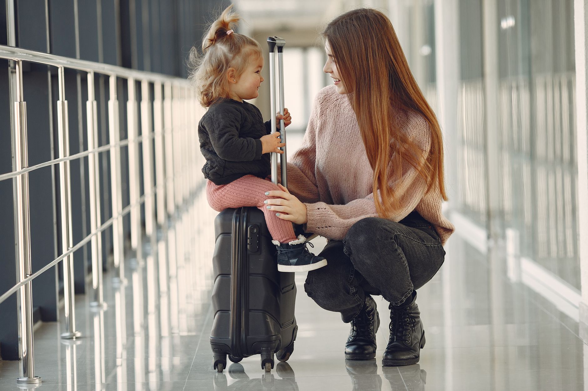 family with suitcase and dog waiting at ferry terminal departure hall