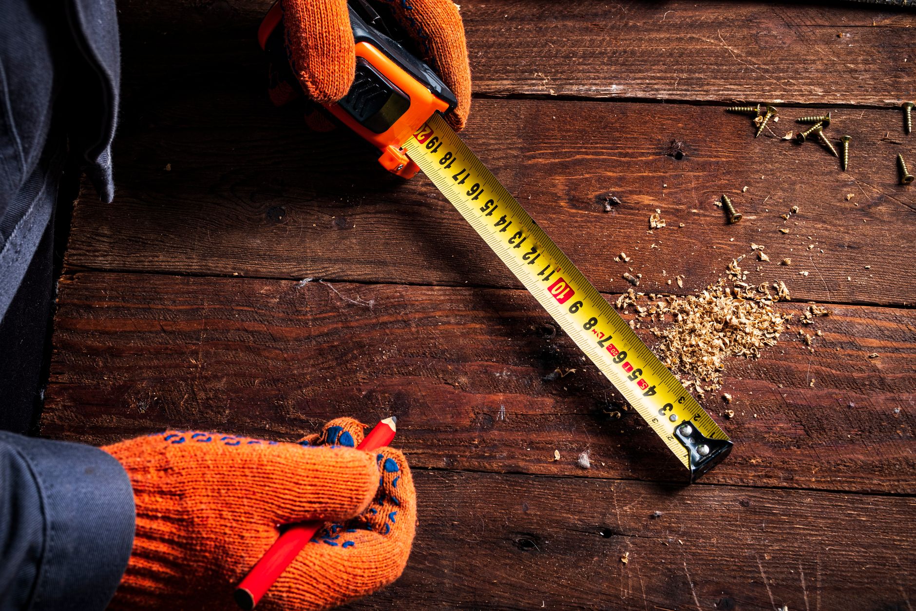 owner measuring dog with tape measure beside travel kennel at home