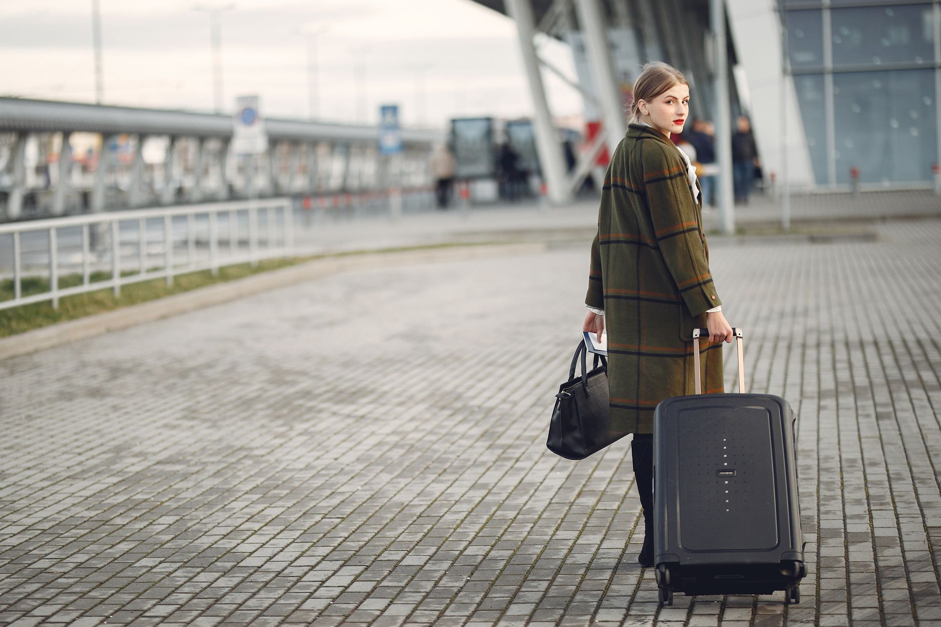 woman carrying pet carrier through airport terminal
