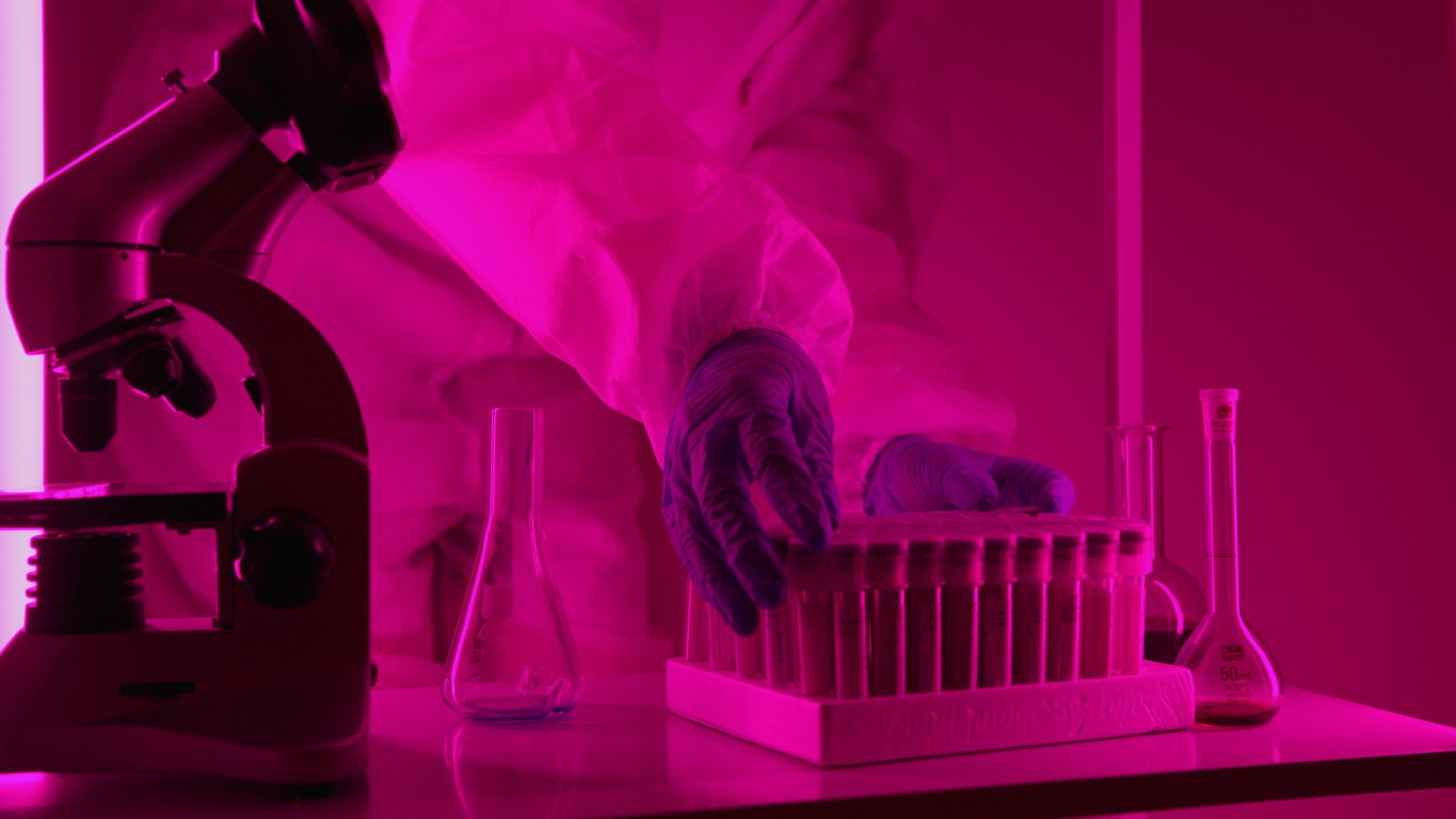 veterinary laboratory technician testing serum vials microscope