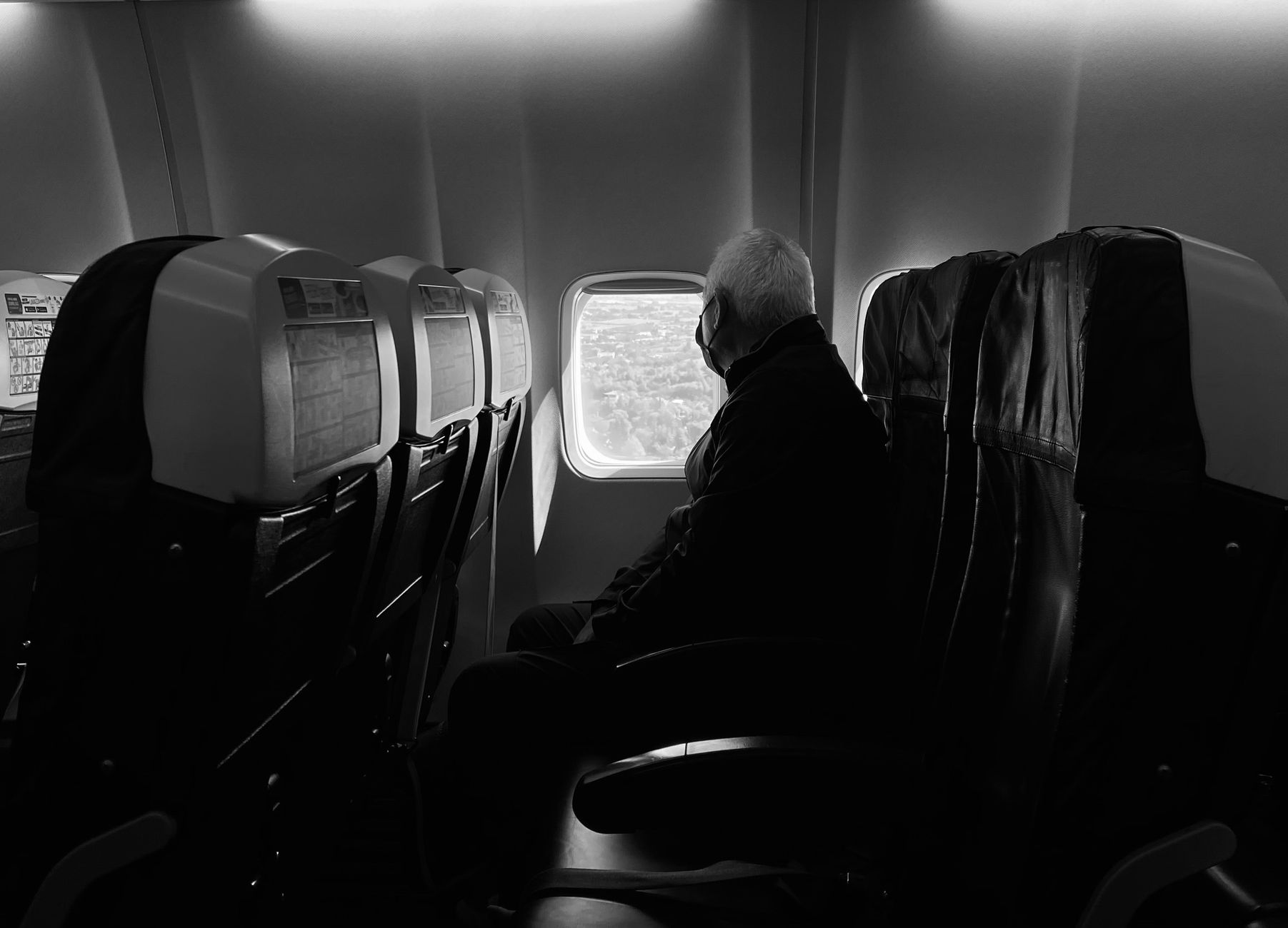 passenger measuring pet carrier with tape beside airline seat