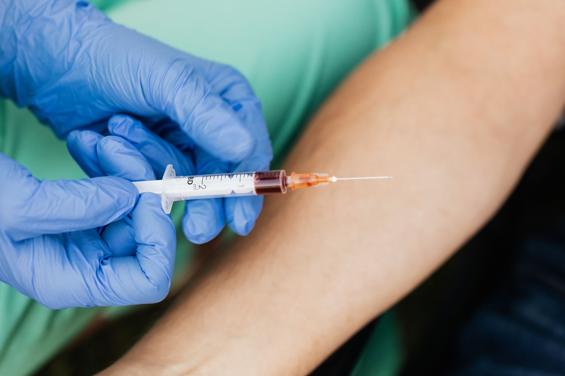 veterinarian drawing blood sample from dog clinic