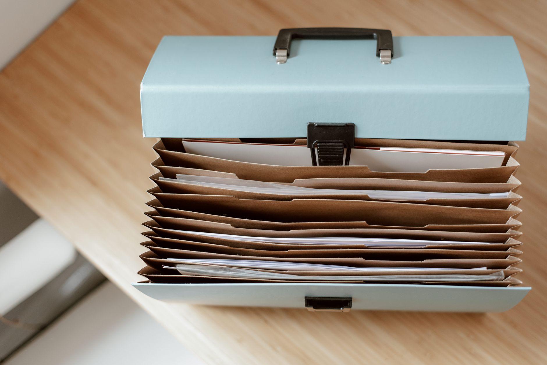 small dog airline cabin carrier beside travel paperwork folder