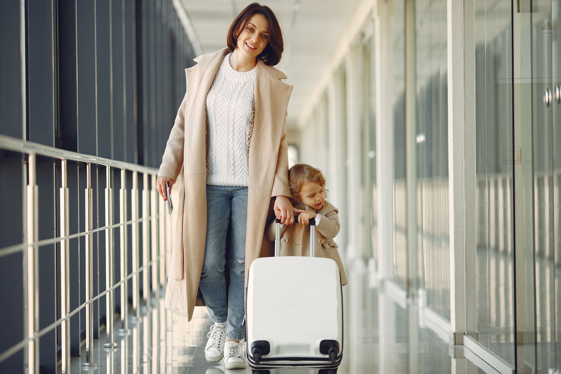woman carrying dog travel carrier through airport terminal