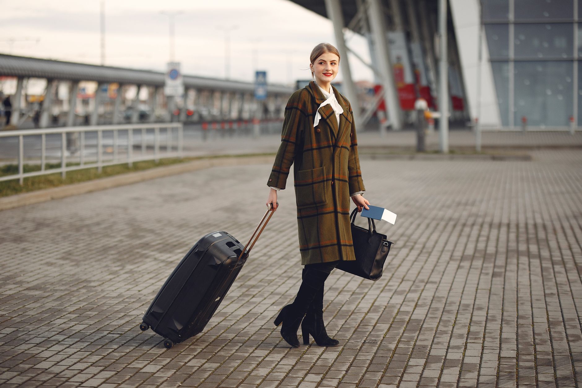 passenger reviewing travel documents with pet carrier in airport terminal