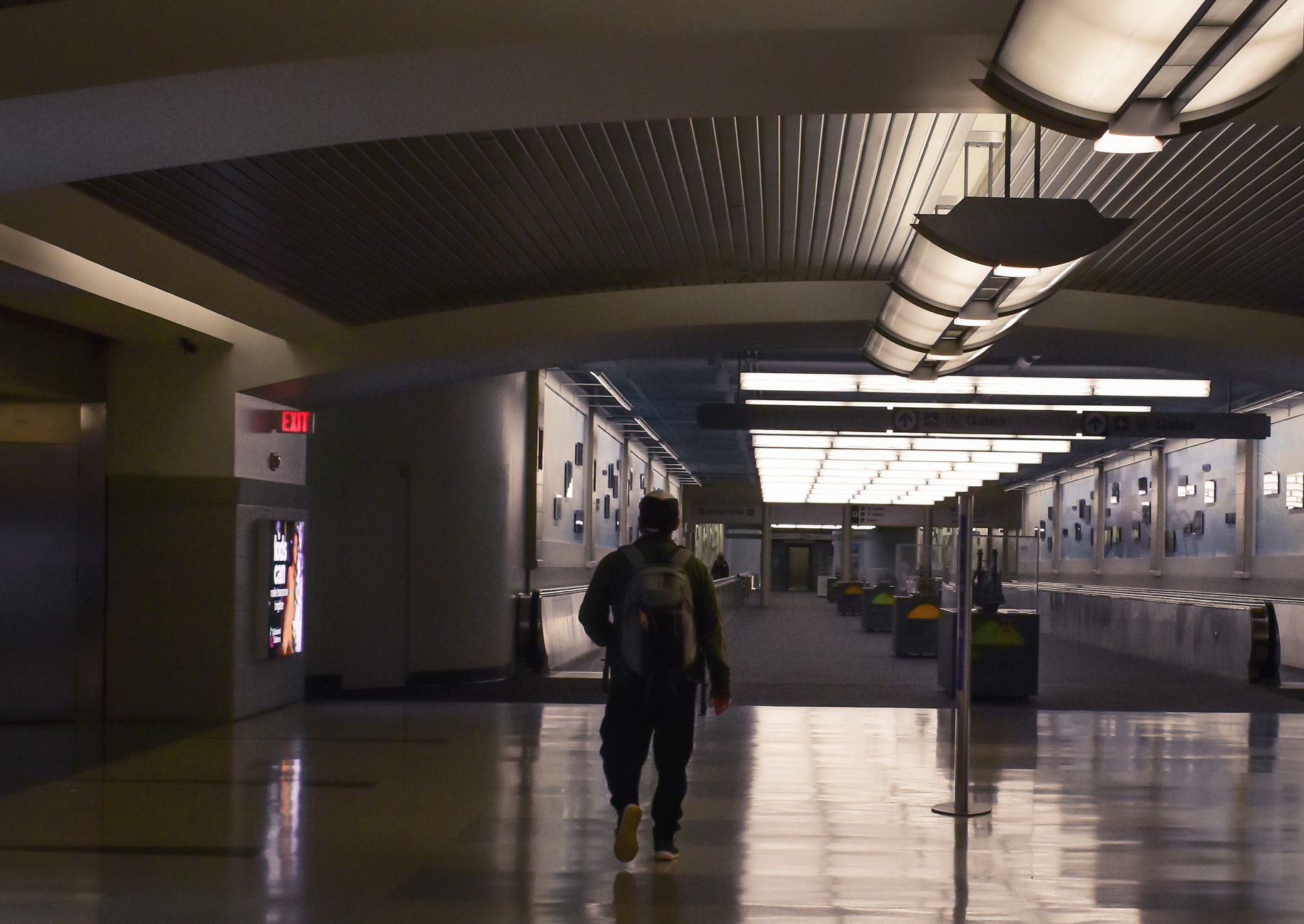 passenger rolling pet stroller through airport terminal corridor