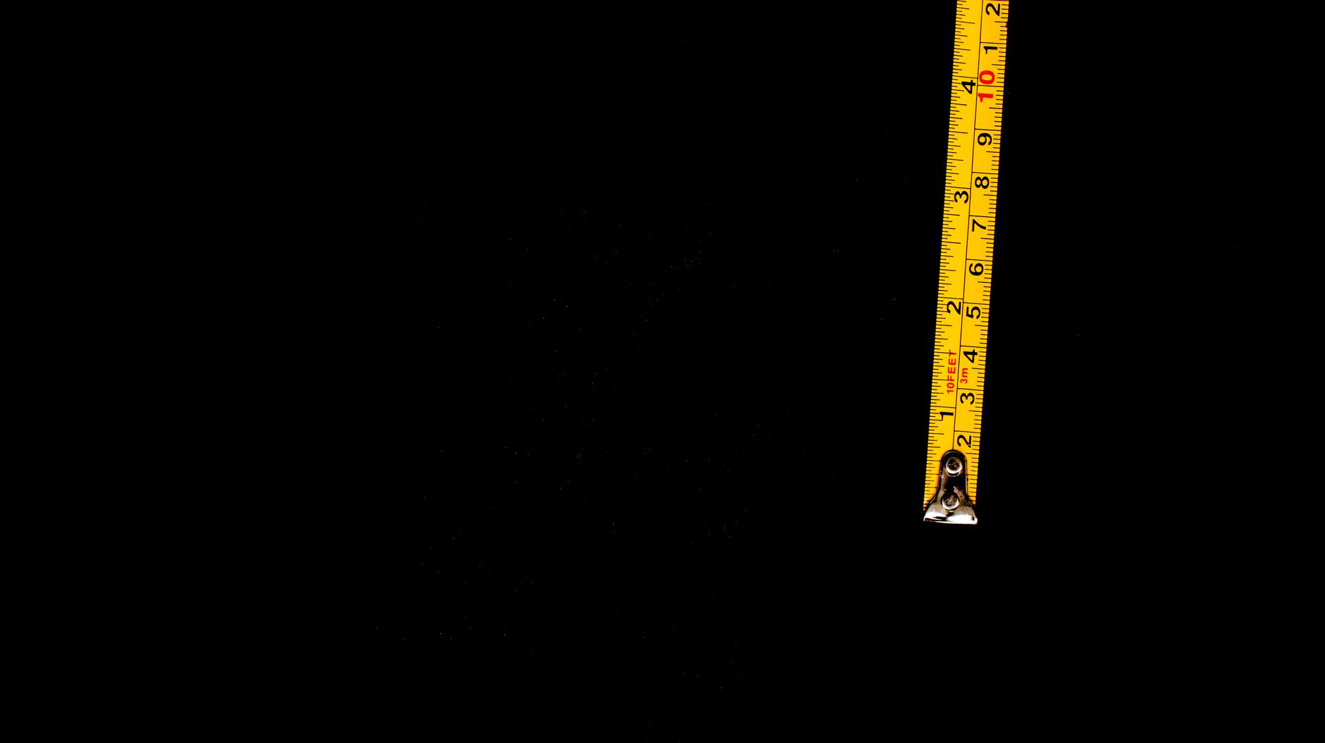 passenger measuring pet carrier length with tape beside aircraft window seat