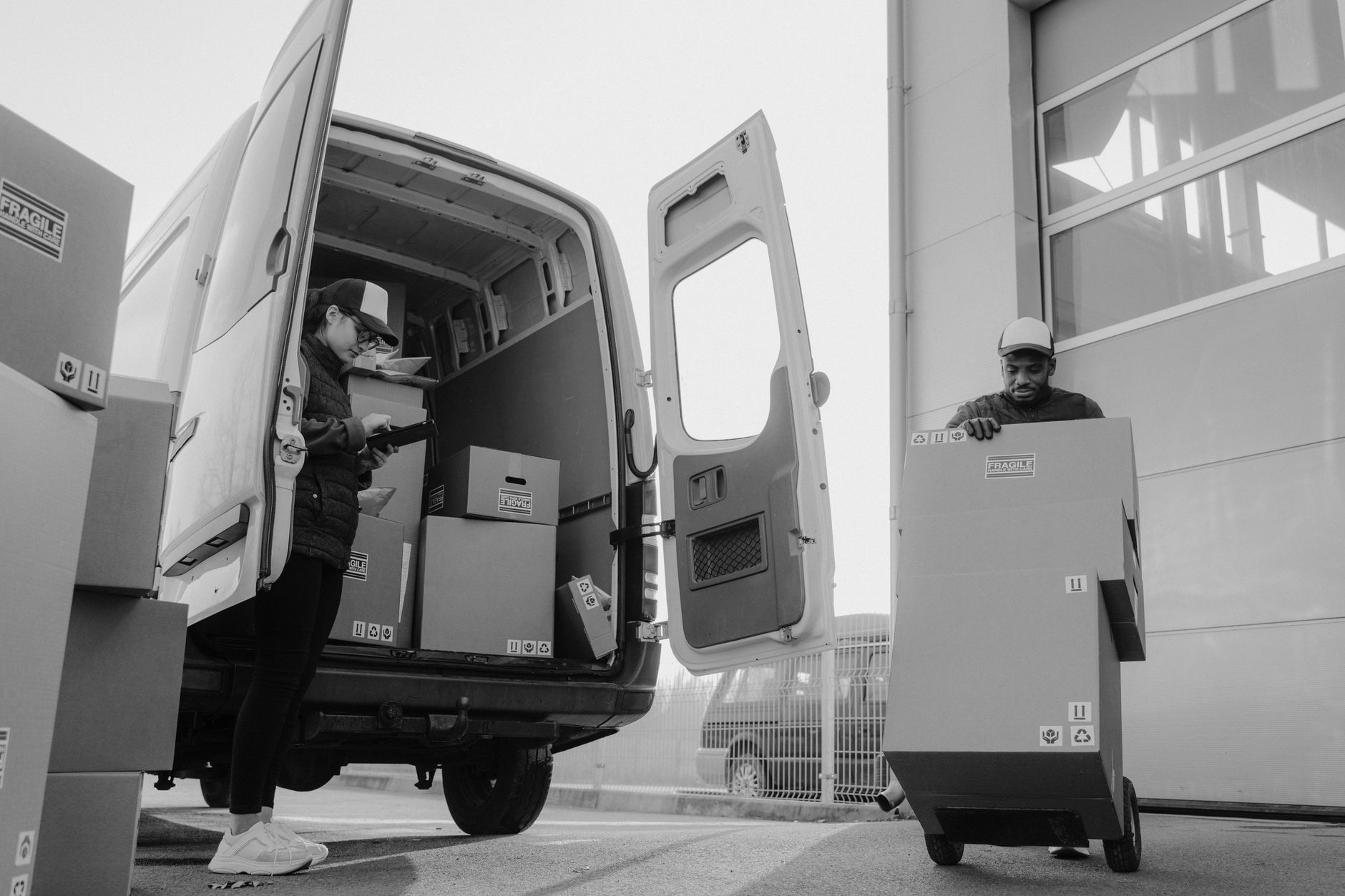 family loading dog crate into moving van driveway